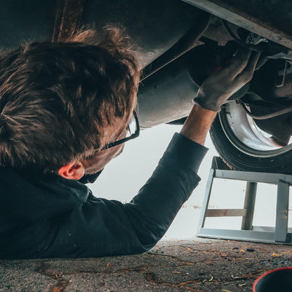 Ein Mechaniker schraubt an einem Auto in einer Autowerkstatt