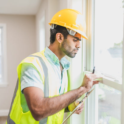 Ein Fensterbauer untersucht ein Fenster